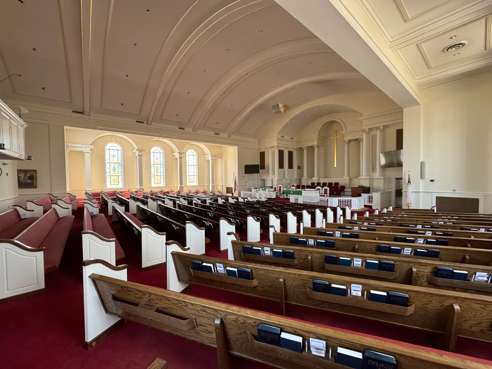 Georgia church sanctuary with pews, stained glass windows, and cross — the property church insurance protects