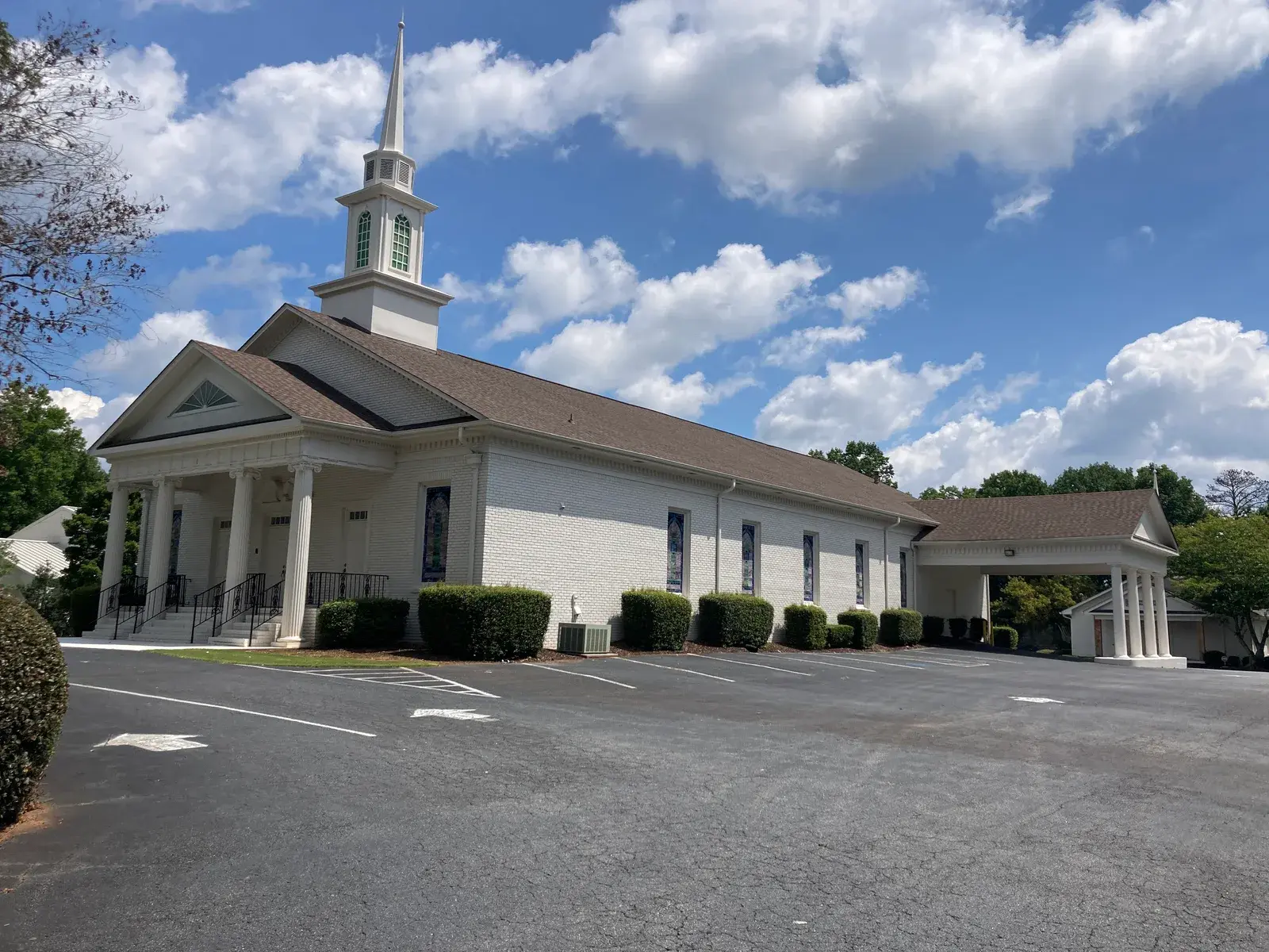 White brick Georgia church with steeple and parking lot — typical mid-size church that needs proper insurance coverage
