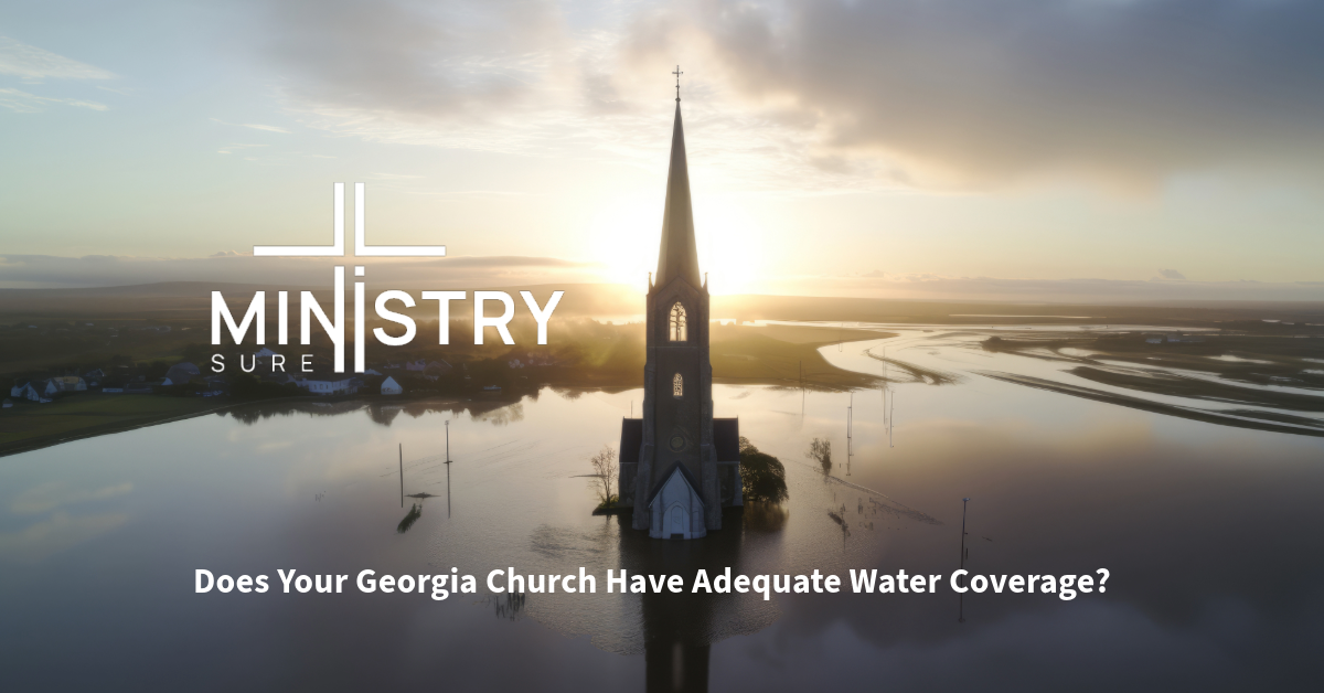 The image shows a church partially submerged in water with a calm body of water surrounding it, likely due to flooding. The sun is setting or rising in the background, casting a warm glow over the scene. The church’s steeple stands tall against the sky, creating a poignant contrast between the serene beauty and the evident water damage. The logo of MinistrySure is prominently displayed above the church with the text "Does Your Georgia Church Have Adequate Water Coverage?" below it.