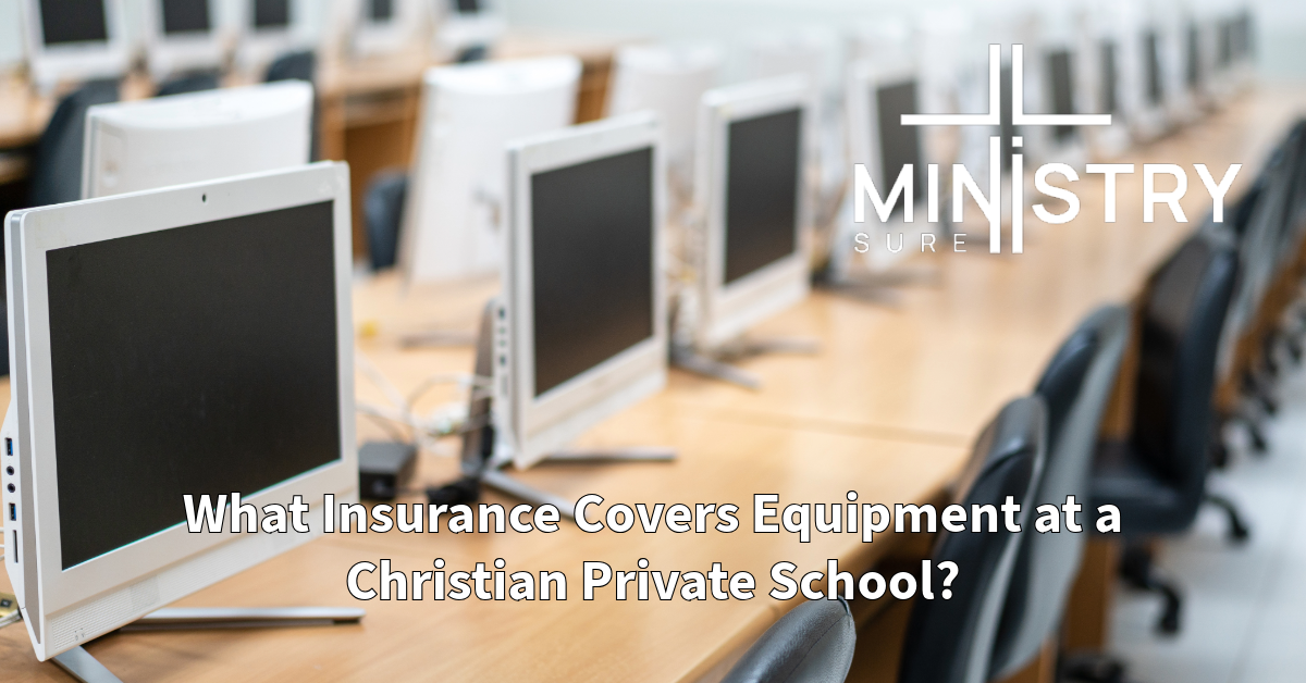 A classroom filled with several computer monitors on wooden desks, arranged in rows. The screen displays the MinistrySure logo in the upper right corner. The text below the monitors reads, "What Insurance Covers Equipment at a Christian Private School?"